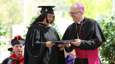 Bishop Szkredka presents a diploma to a graduate